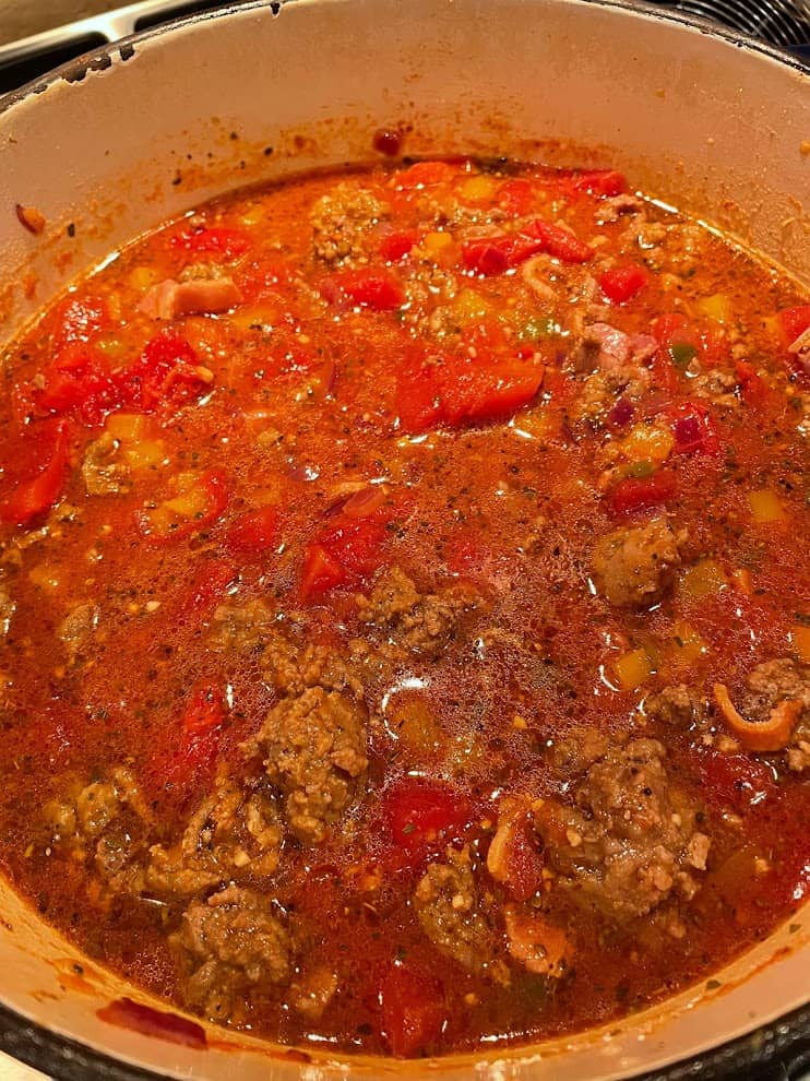 simmering chili on a stove in a dutch oven