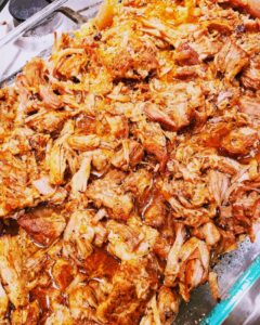 Carnitas in a pan pulled into small pieces
