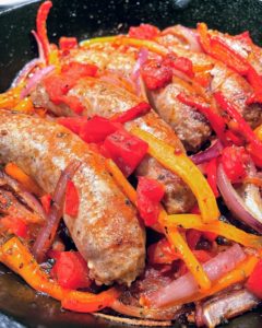 Italian sausage, bell peppers, tomatoes and red onions cooked in a cast iron skillet