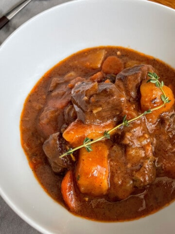 Beef Stew in a bowl with chunky carrots and fresh thyme
