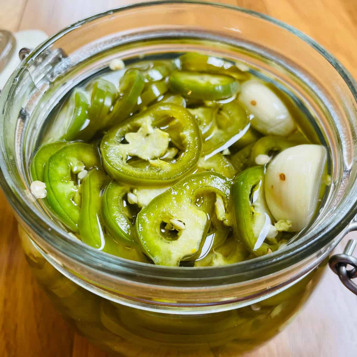 Thin sliced jalapeños in a jar of pickling liquid