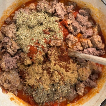 dutch oven filled with meat, spices, and tomatoes