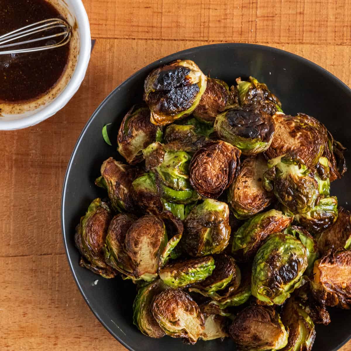 bowl of crispy Brussels sprouts with spicy balsamic sauce.