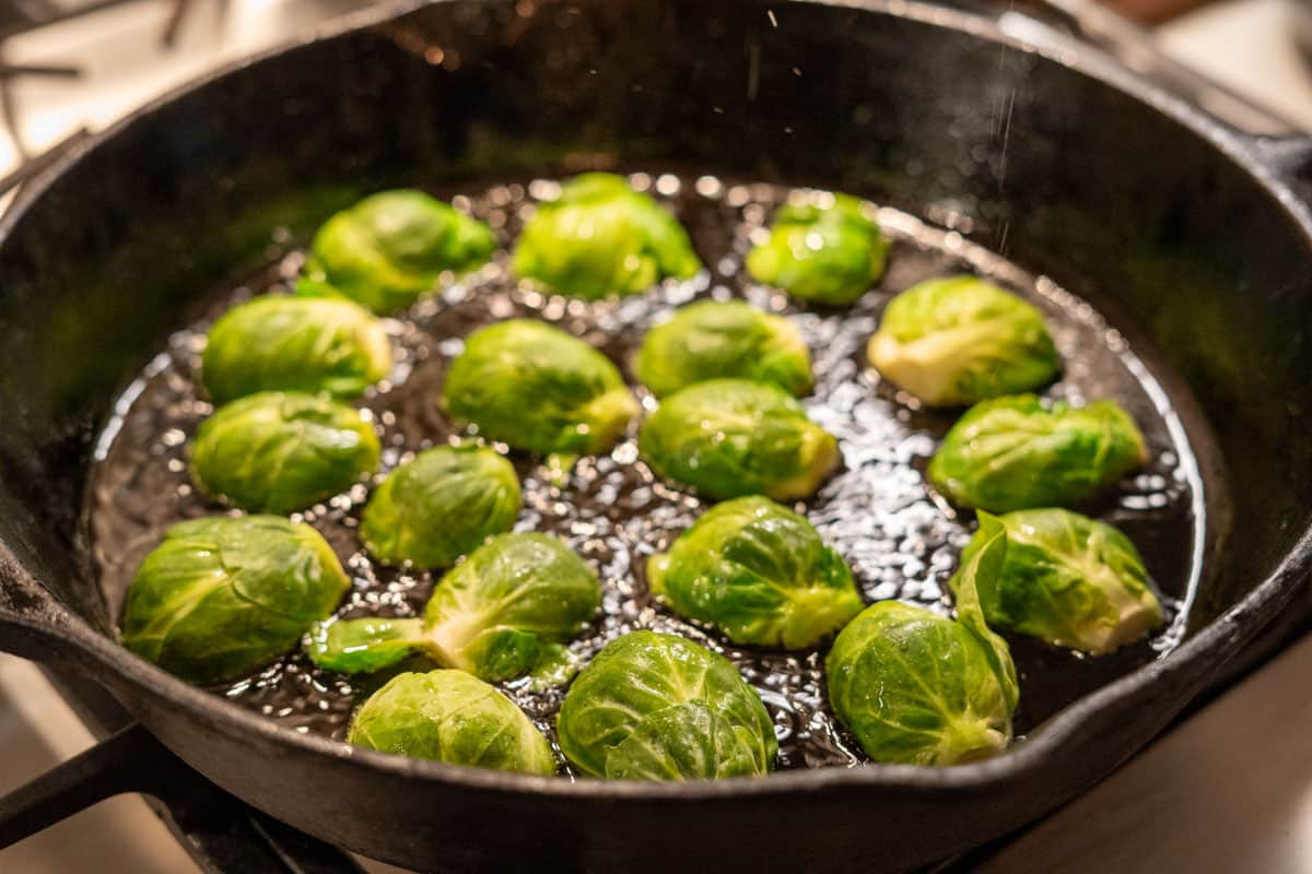 brussel spouts cooking in a cast iron pan