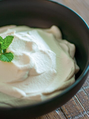 Bowl of homemade whipped cream with fresh mint