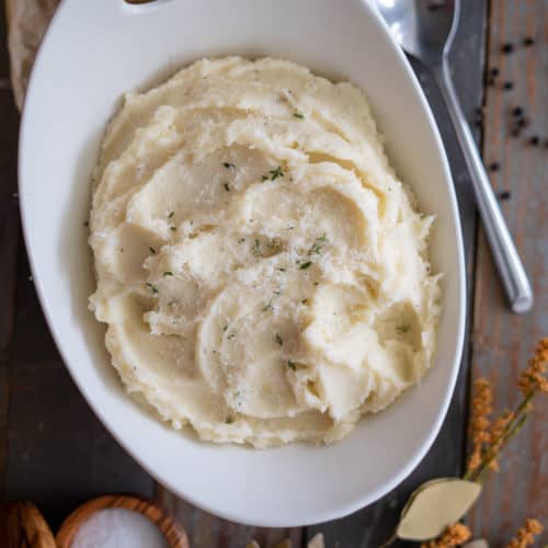 Parmesan Mashed Potatoes in a bowl with thyme on top