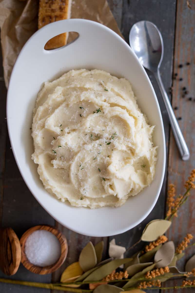 Parmesan Mashed Potatoes in a bowl with thyme on top