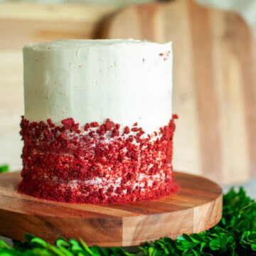 Small Red velvet cake with crumbled red velvet pieces around the bottom