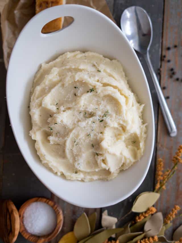 Parmesan Mashed Potatoes in a bowl with thyme on top