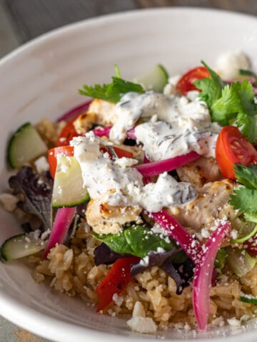 Brown rice, greek chicken and salad with a variety of toppings.