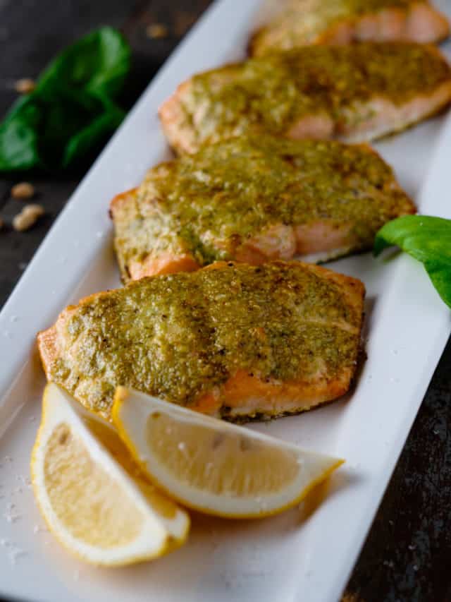 Salmon Roasted with Pesto Butter on a Plate with Lemon Wedges