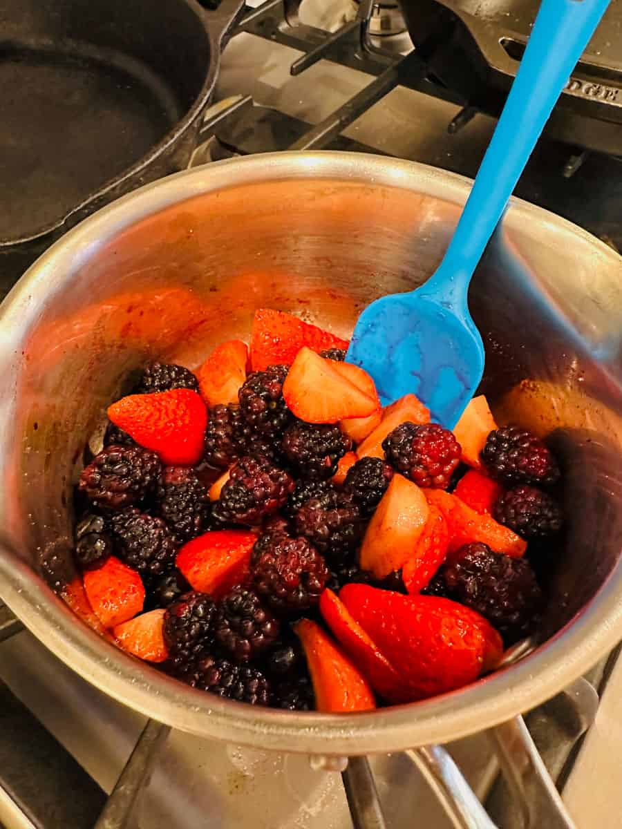 blackberries, blueberries, strawberries, and rasperries in a small sauce pot ready to be cooked