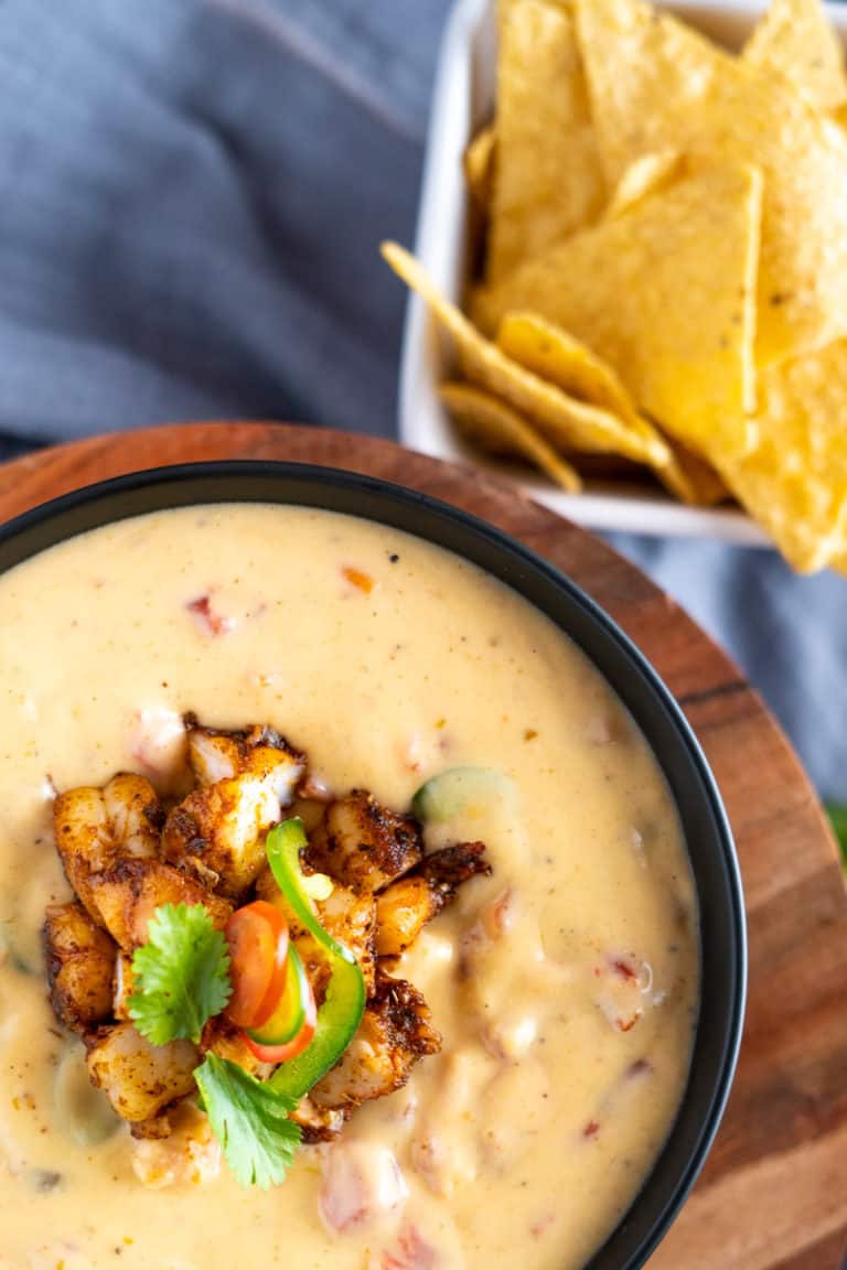 Shrimp queso in a bowl next to tortilla chips