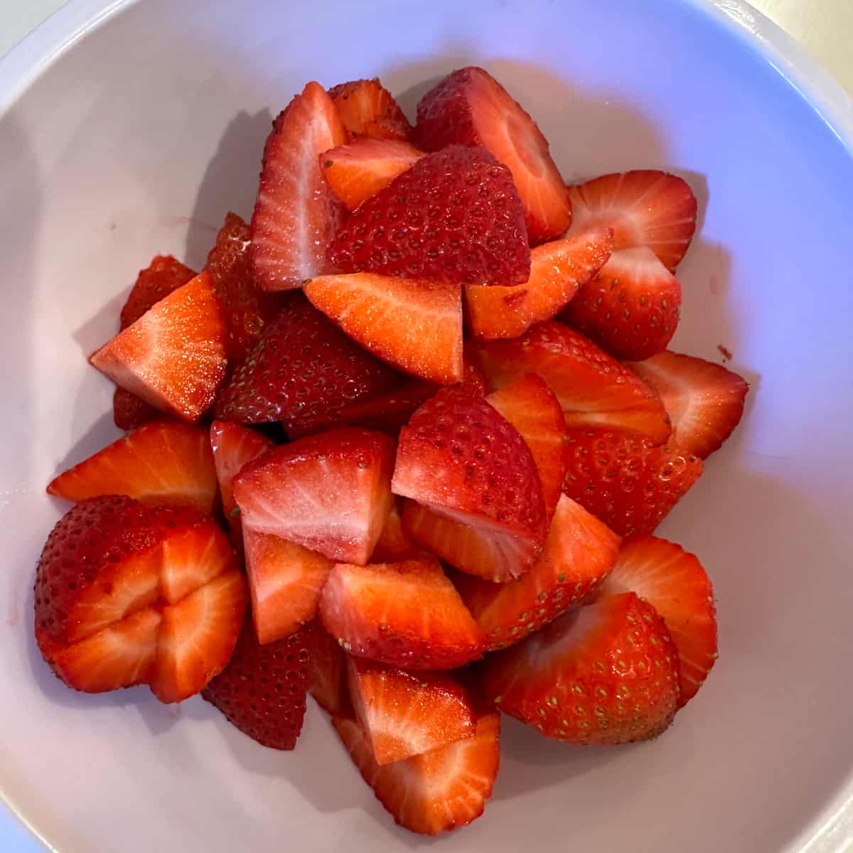 Cut-up strawberries in a plastic bowl