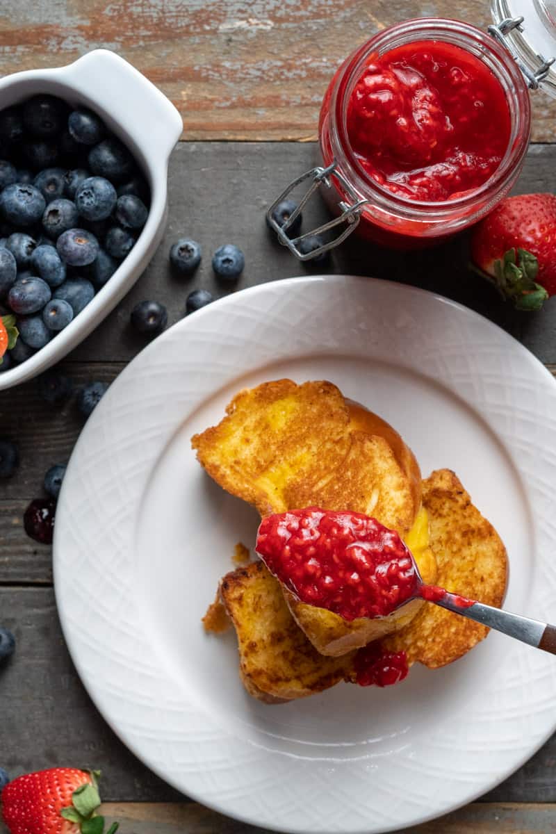 Raspberry Compote in a spoon over Brioche Toast