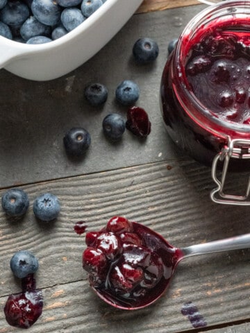 Blueberry compote on a spoon laying on a table
