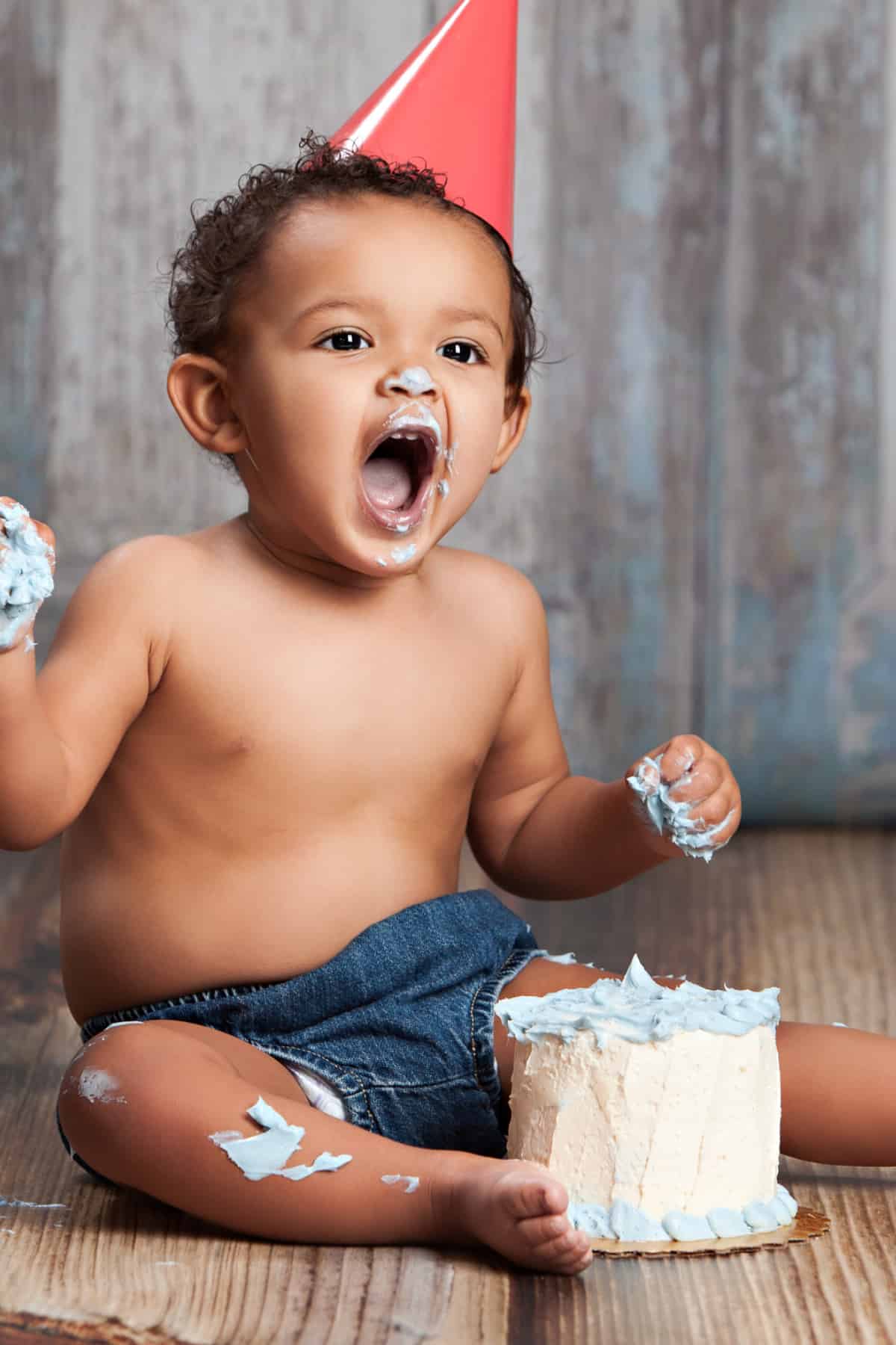 Baby sitting on the floor eating cake