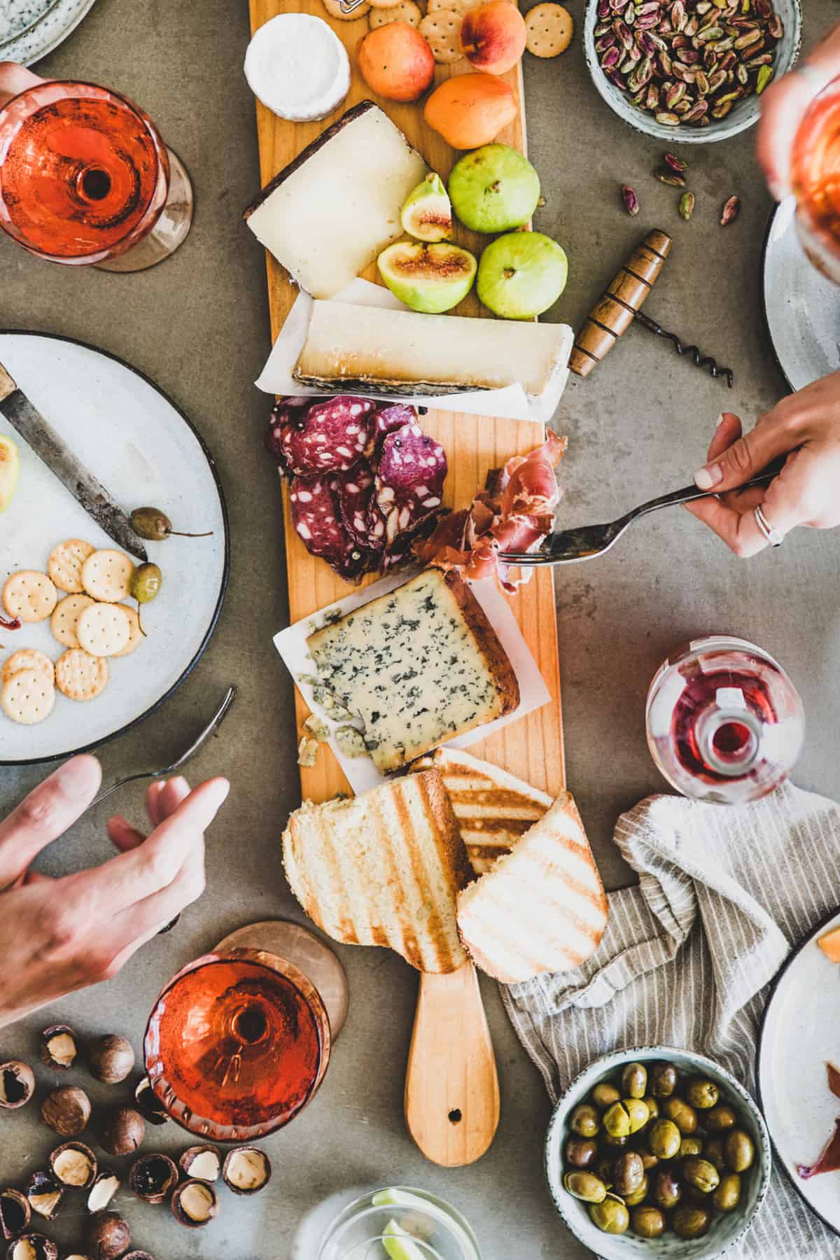 Charcuterie Board on table with wine glasses and people eating