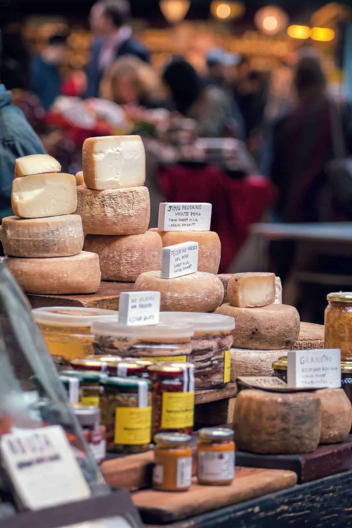 Upscale grocery store deli feature large wheels of imported cheese