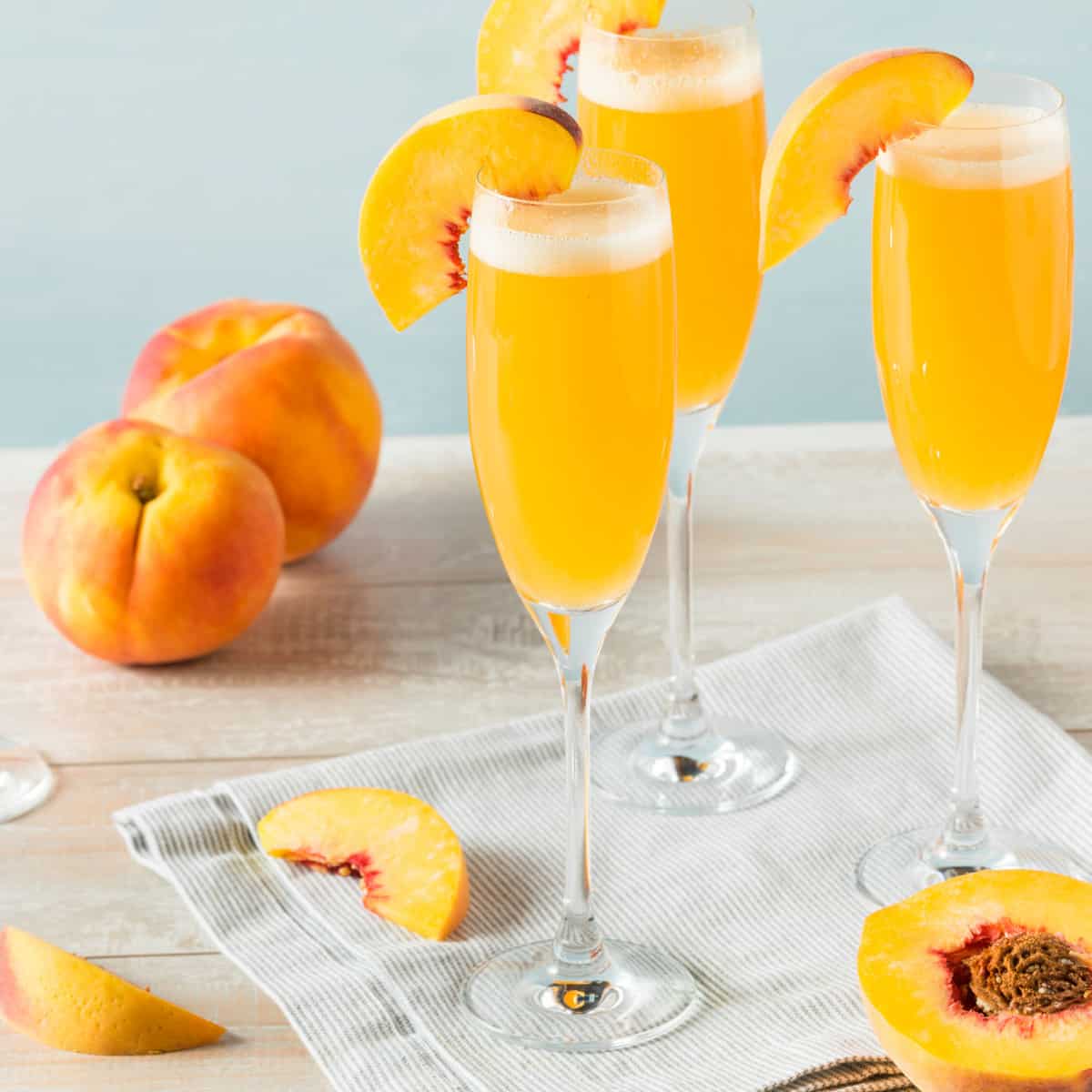 Bellini in a champagne flute garnished with a fresh peach