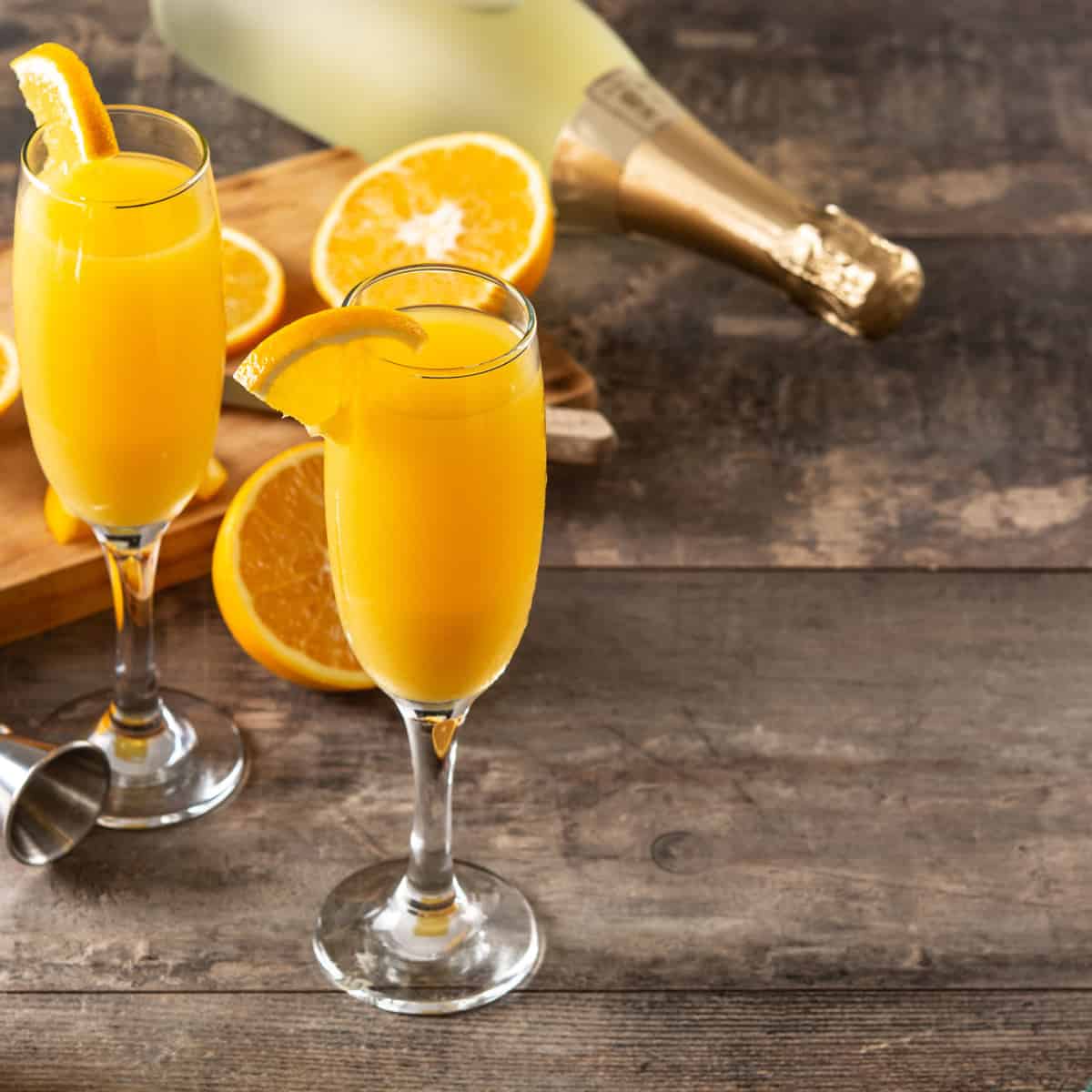Mimosa in a champagne glass garnished with fresh orange 
