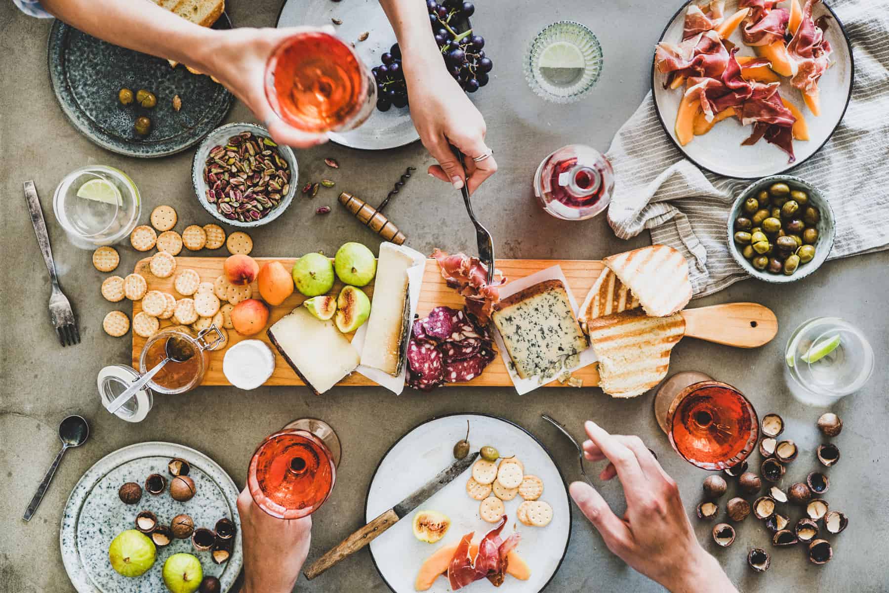 Long skinny charcuterie board being enjoyed by a party