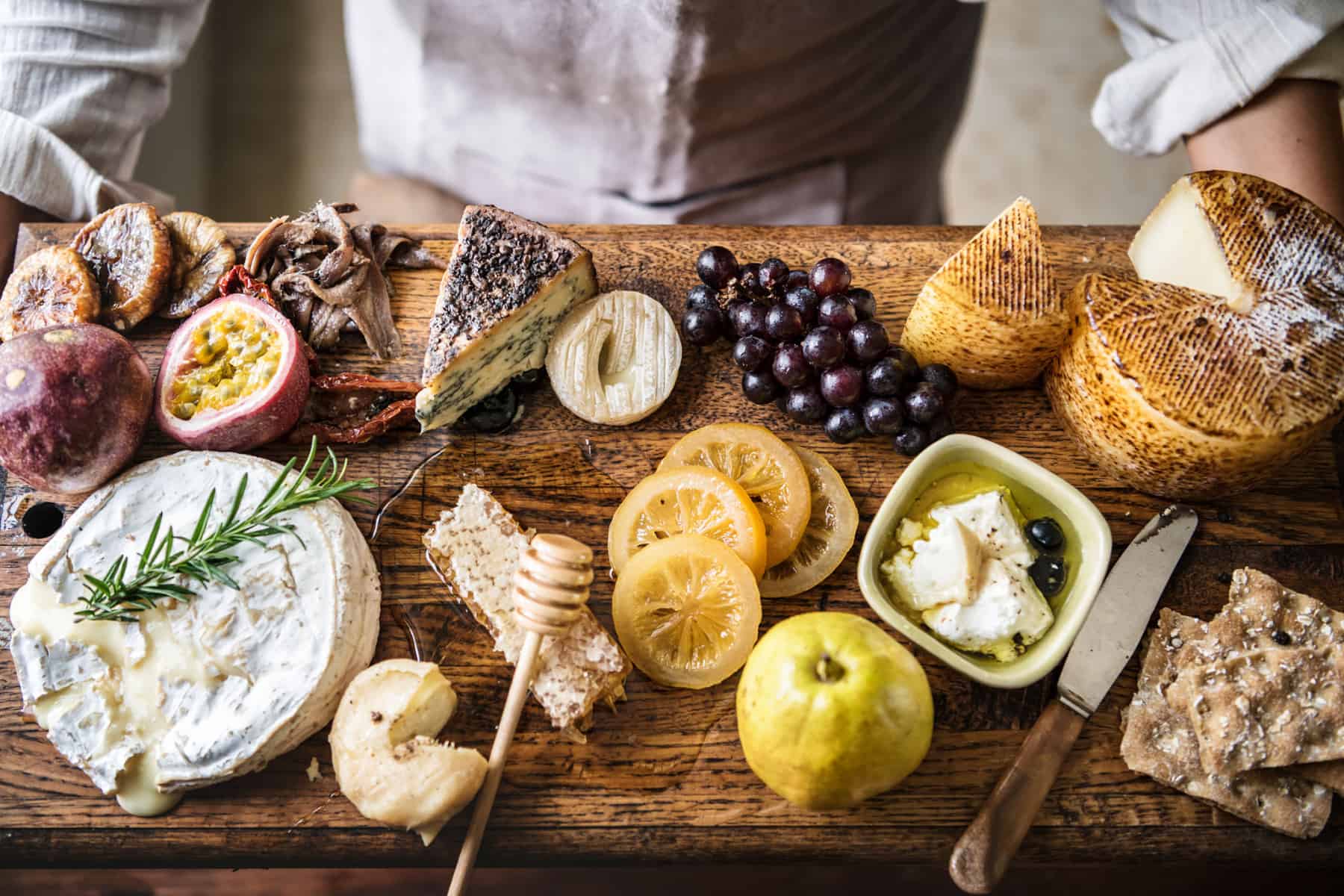 Cheese and fruit charcuterie board being held by a chef