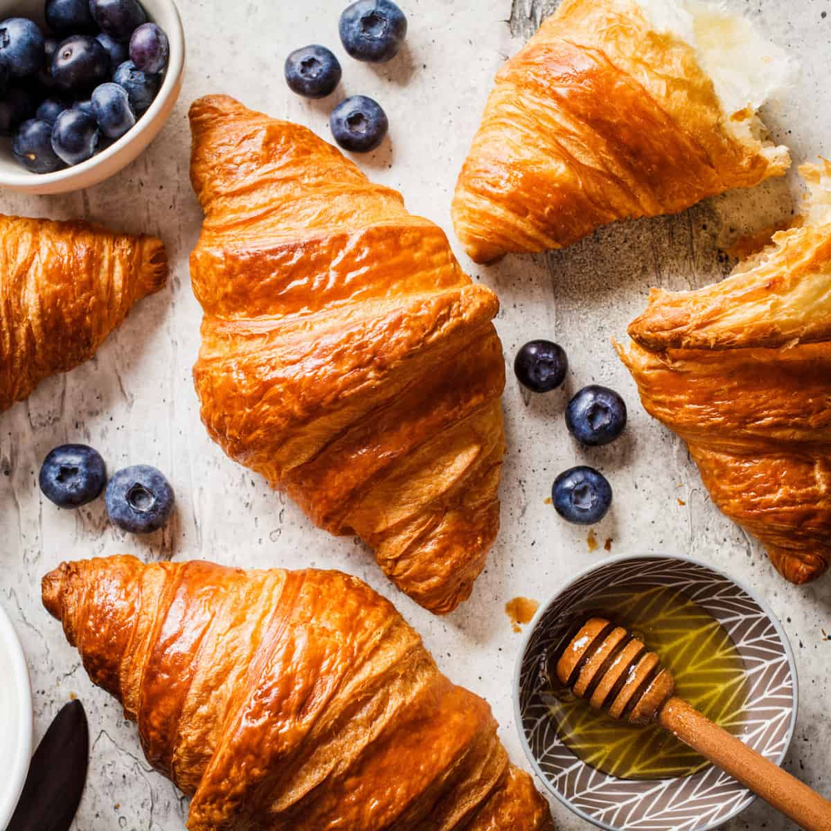 croissants in a table with fresh blueberries and honey 