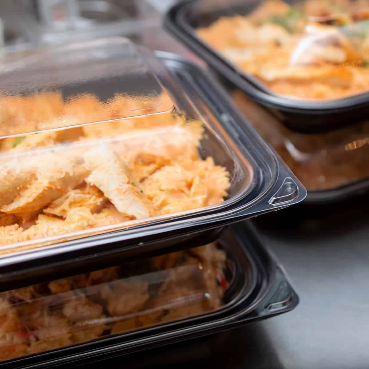 Plastic to go containers filed with leftovers