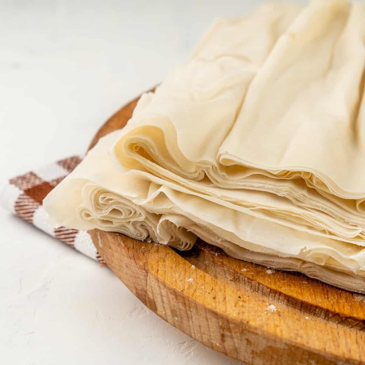 sheets of thin phyllo dough on a wooden board