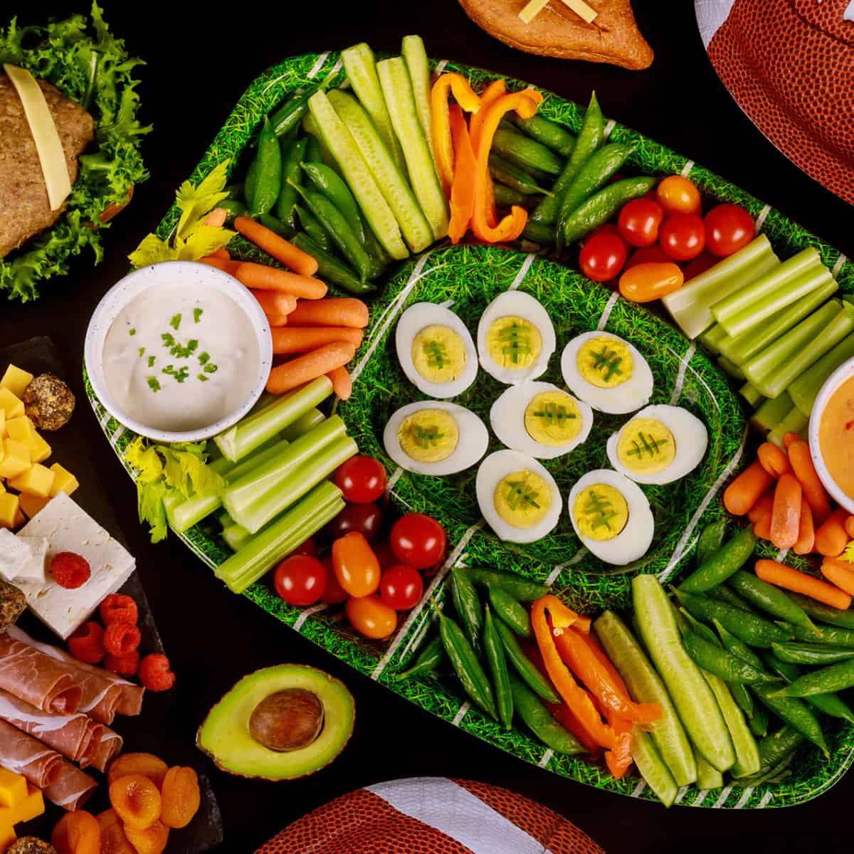 Football Charcuterie Board with deviled eggs in the center and veggies in the "stands"