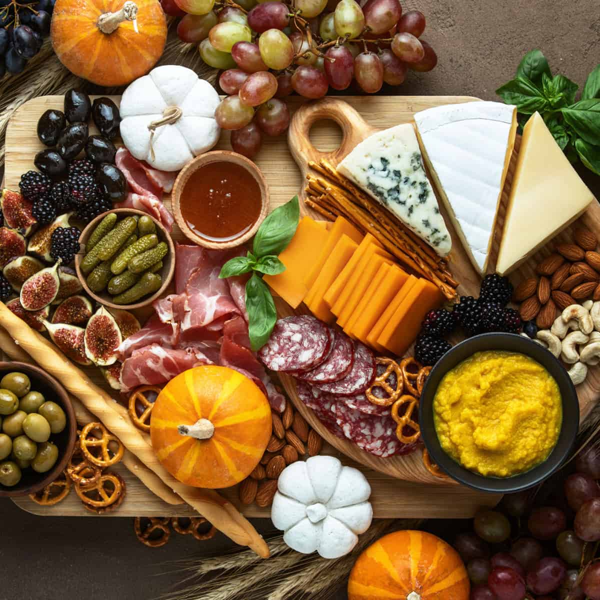 Thanksgiving Charcuterie Board with mini pumpkins and orange pops 