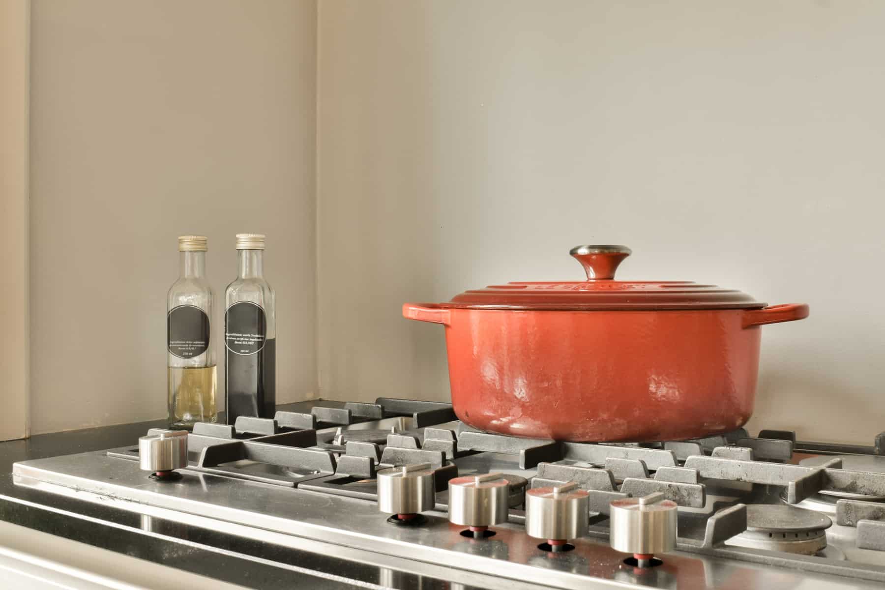 Orange, oval dutch oven on a gas cooktop