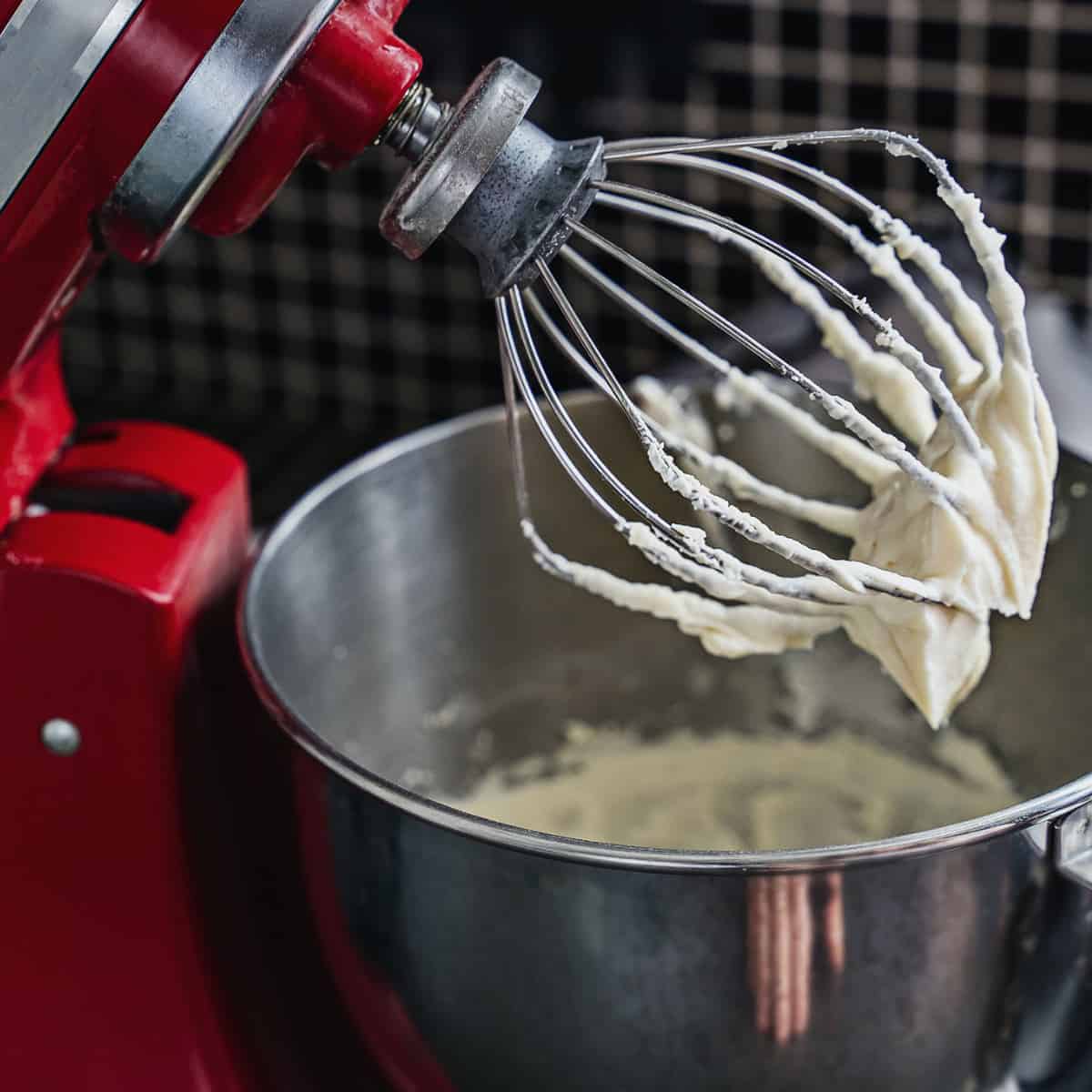 Upclose view of a KitchenAid whisk with frosting on it