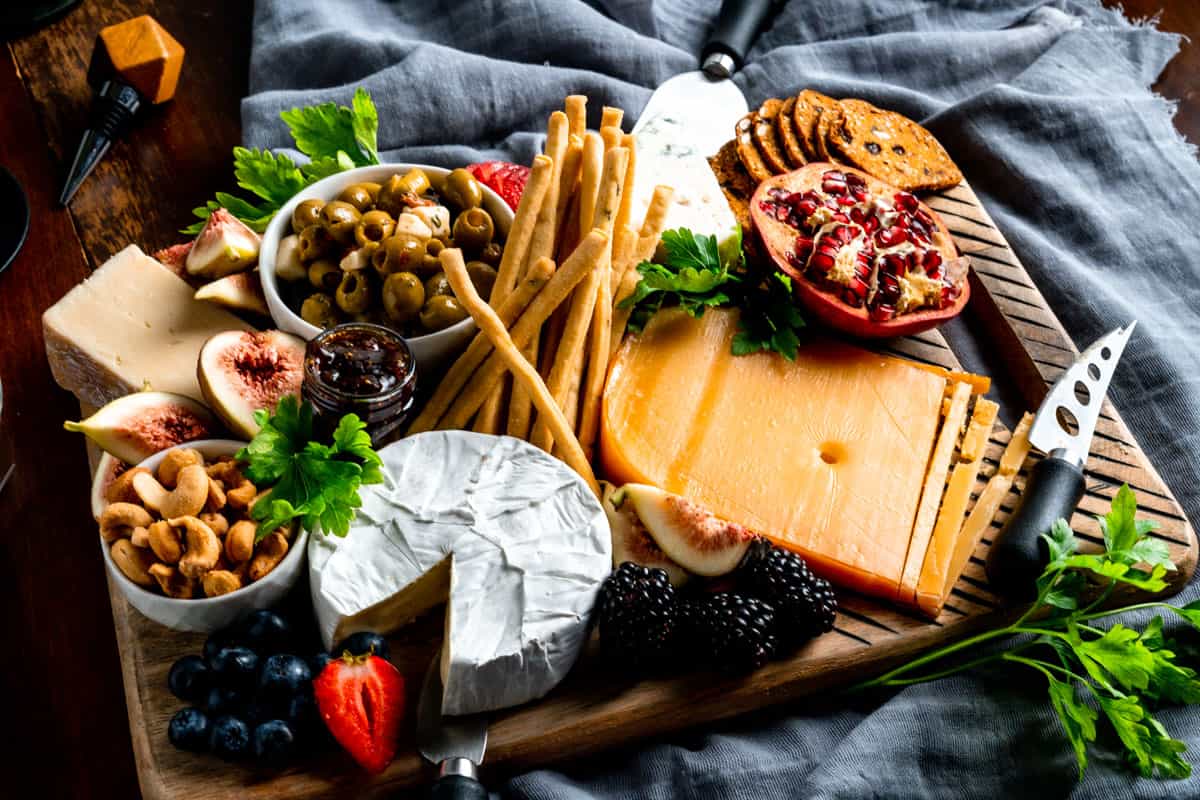 medium cheese board with brie, aged gouda, olives, and crackers