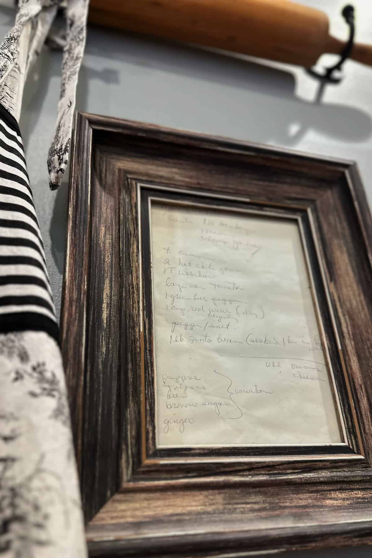 old handwritten recipe, framed and hung next to rolling pin and apron