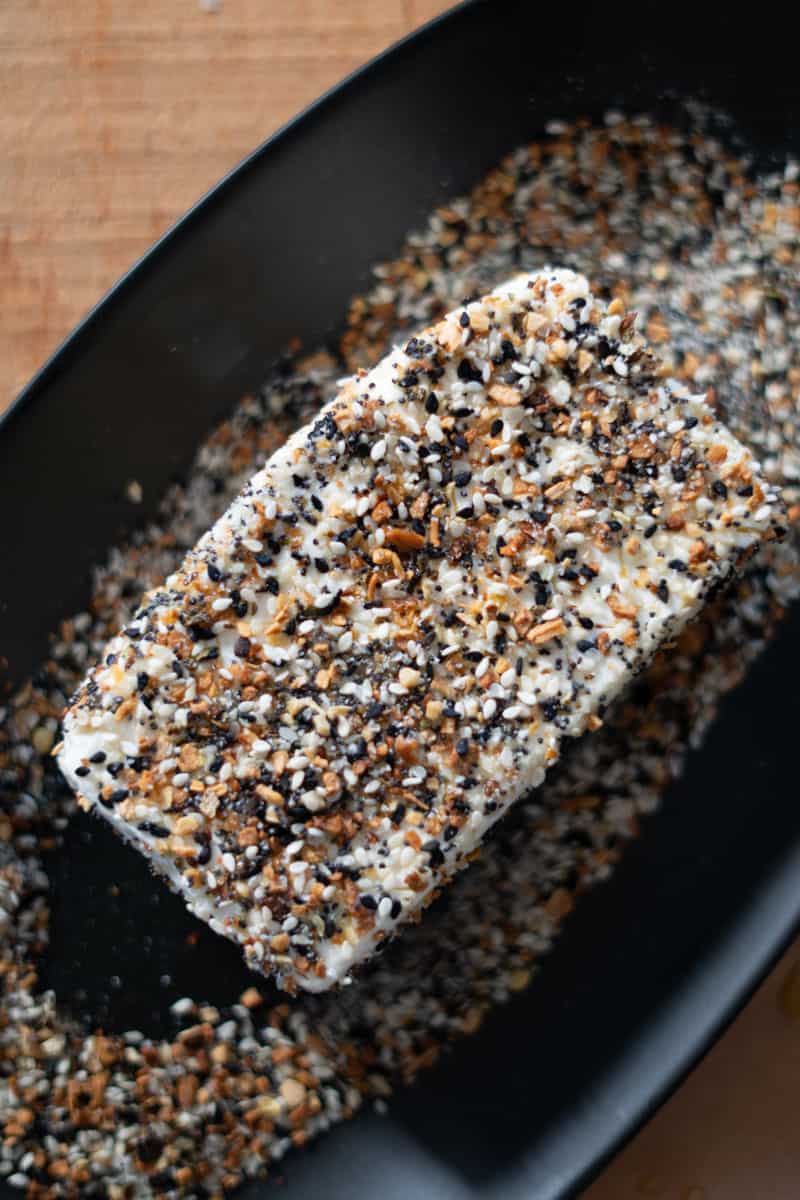 A cream cheese block fully coated with everything bagel seasoning